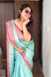 Woman wearing a Turquoise Blue Pure Tissue Cotton Saree with Rich Red Border with pink border indoors