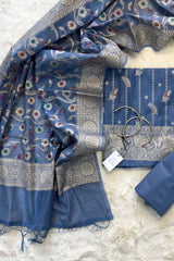 Dusty Blue Muga Silk in Minakari work Unstitched Suit with a tag on a light gray background