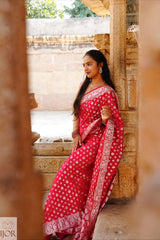 Nandini Yallareddy in Banarasi Soft Georgette Silk Red Saree with silver booti sitting in a temple setting