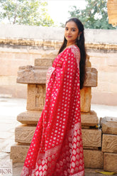 Nandini Yallareddy in Banarasi Soft Georgette Silk Red Saree with in silver booti showing anchal of saree standing in front of stone steps.