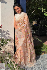 Gana Murali in a traditional Banarasi Soft Organza Silk Saree Golden standing outdoors under the sun kissed light.