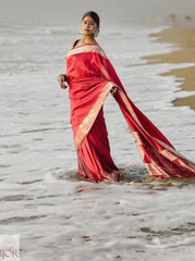 Divya Darshini ft. in Banarasi Soft Semi Katan Silk Saree Red standing in shallow water at the beach
