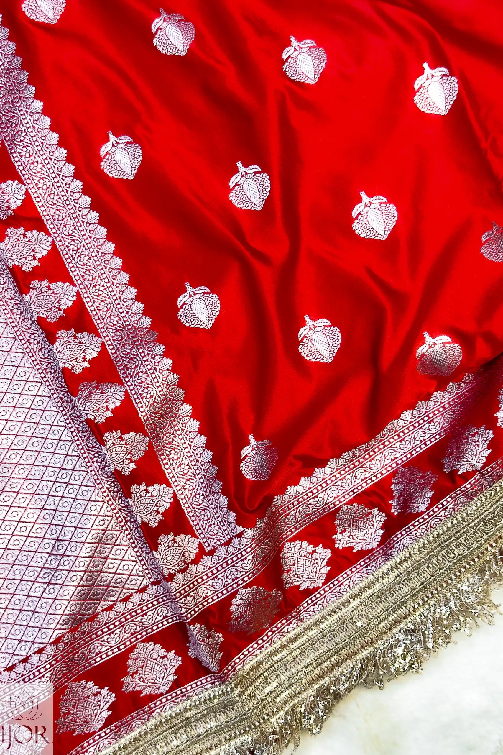 Red Mashru Silk Saree with Maharani Lace with white floral patterns and intricate border on a white background