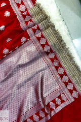 Close-up of a Red Mashru Silk Saree with Maharani Lace patterns and gold trim.