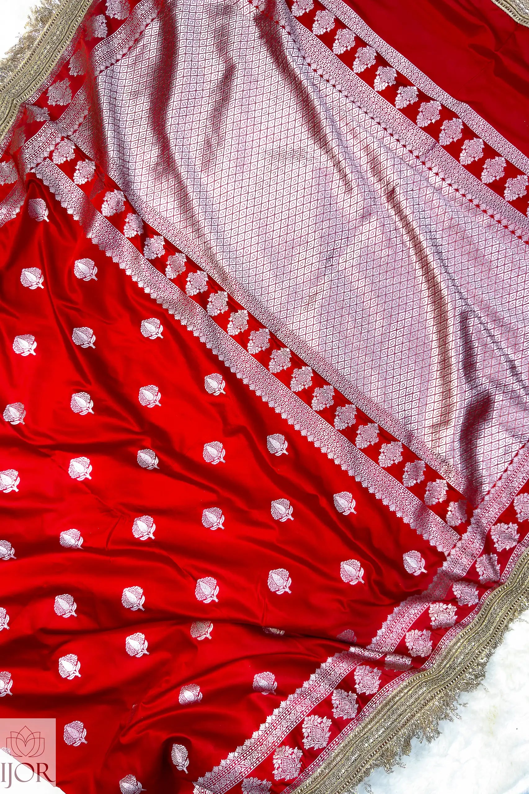 Red Mashru Silk Saree with Maharani Lace embroidery on a textured surface