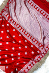 Red Mashru Silk Saree with Maharani Lace embroidery on a textured surface