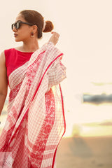 Woman wearing a Dhonkhali Red and White Pure Cotton Check saree with a blurred background