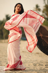 Woman wearing a Dhonkhali Red and White Pure Cotton Check saree with a blurred background