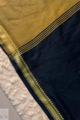 Close-up of a Pure Cotton Saree Black and Yellow border on a textured surface