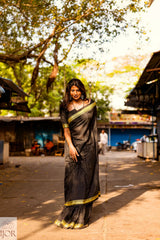 Divya Darshini ft in Jharokha Pure Cotton Saree Black and Yellow border standing outdoors on a street.