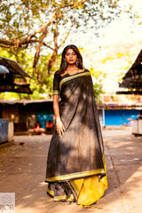 Divya Darshini ft in Jharokha Pure Cotton Saree Black and Yellow standing outdoors with trees and buildings in the background