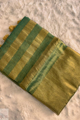 Green Golden Zari Pure Tissue Cotton Saree with tassels on a textured beige background