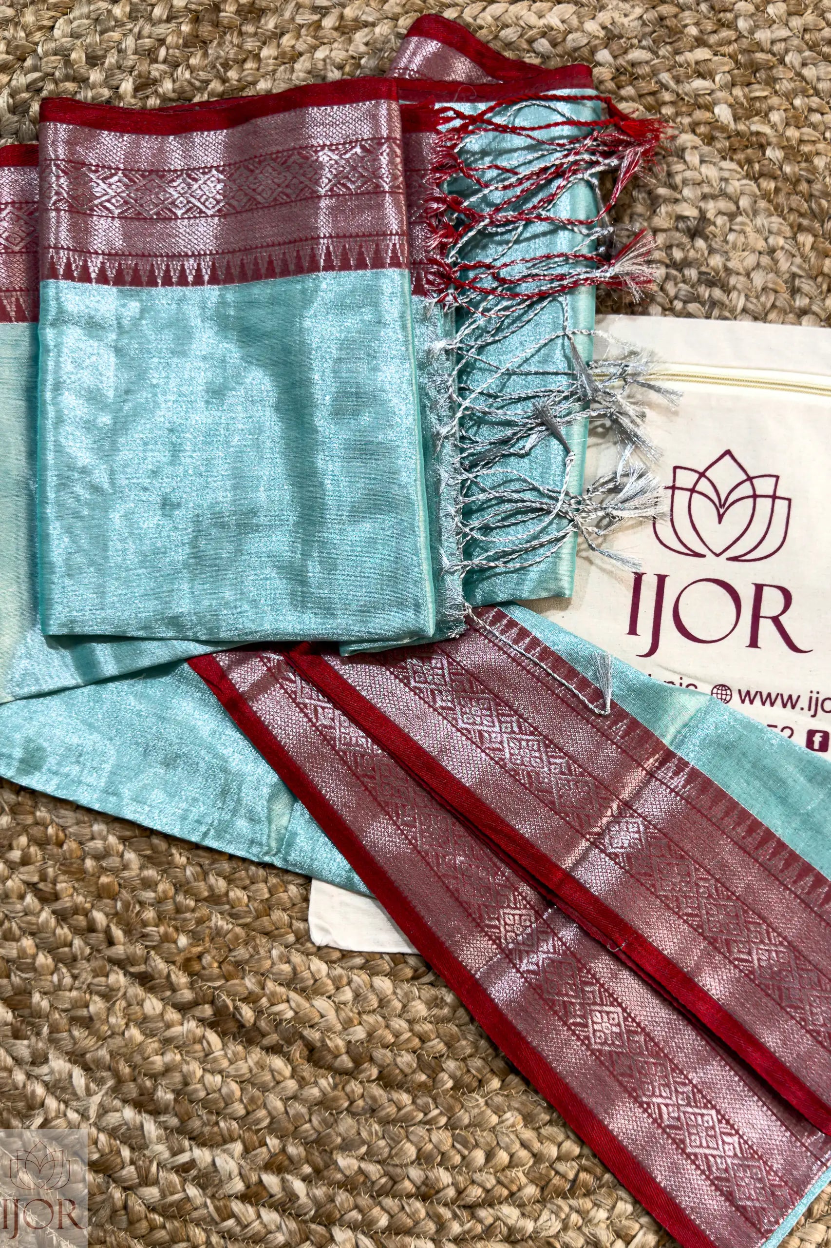 Turquoise Blue Pure Tissue Cotton Saree with Rich Red Border on a textured surface, IJOR brand visible