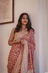 Woman wearing a traditional Banarasi Soft Georgette Silk Brown Saree saree indoors with a neutral background