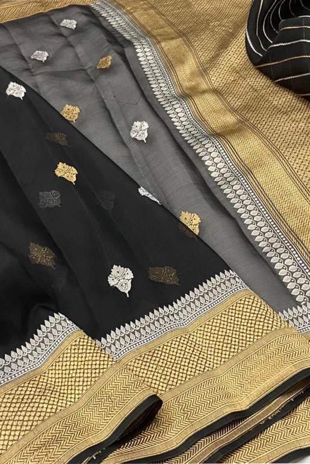 Kora Orgenza Silk Black Saree with intricate patterns on a textured fabric background