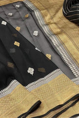 Kora Orgenza Silk Black Saree with intricate patterns on a textured fabric background
