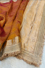 Close-up of a textured fabric with gold and beige patterns on a white background
