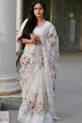 Nav Kaur wearing a Banarasi Soft Organza Silk Saree Ivory with floral patterns standing outdoors.