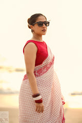 Woman wearing a Dhonkhali Red and White Pure Cotton Check saree with a blurred background
