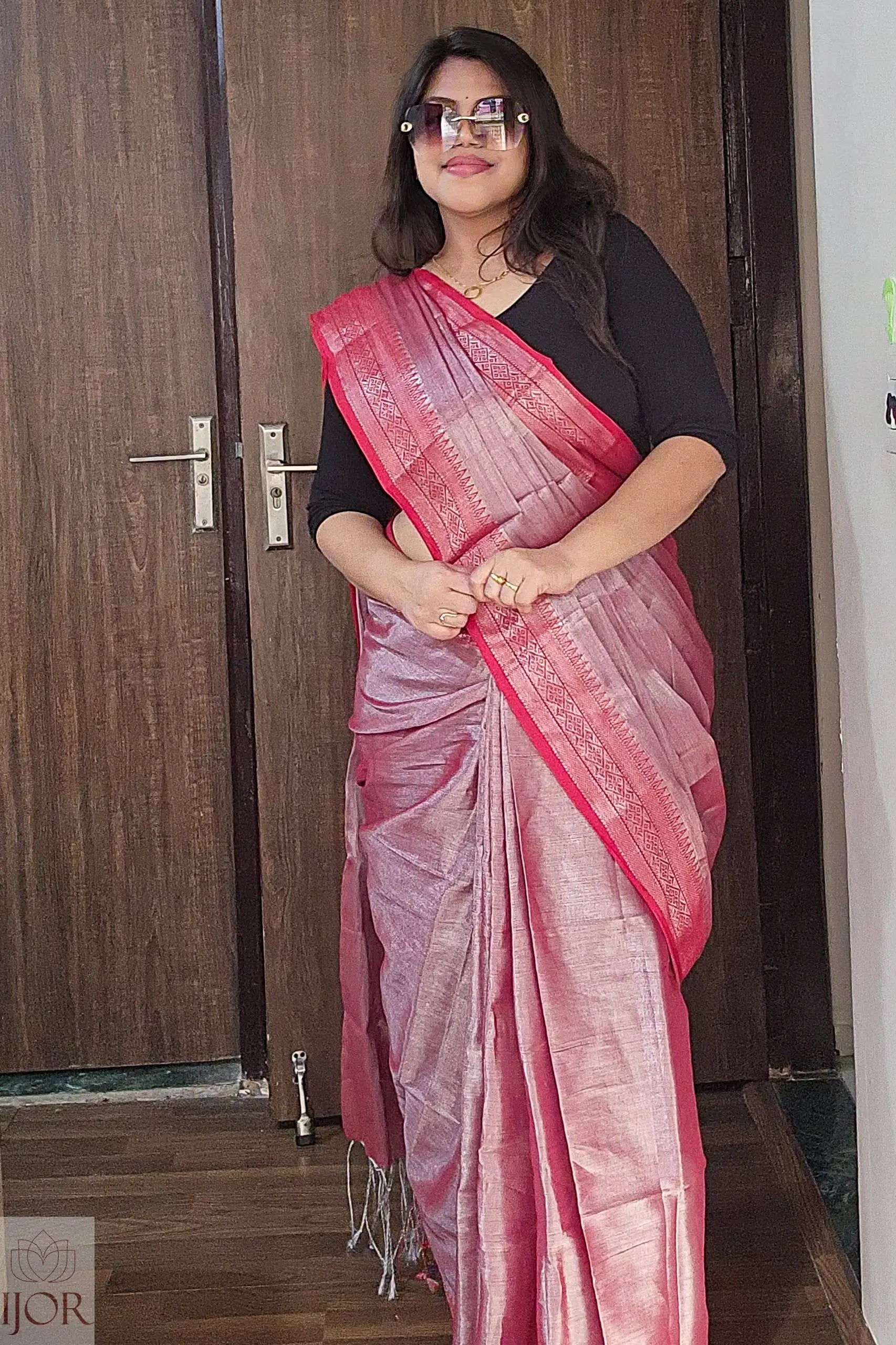 Woman wearing a Lavender Color Tissue Cotton saree with a black blouse .
