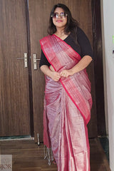 Woman wearing a Lavender Color Tissue Cotton saree with a black blouse .