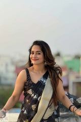 Kavya in a Kora Orgenza Silk Black saree with floral patterns against a blurred outdoor background