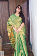   Aarti in Green Golden Zari Pure Tissue Cotton Saree with a black blouse indoors.